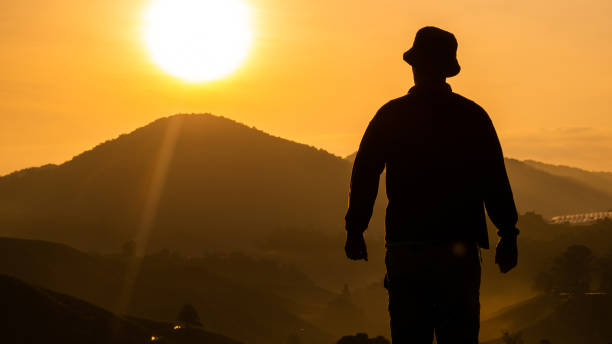 istock Rearview of man standing and watching sunrise 1272259746