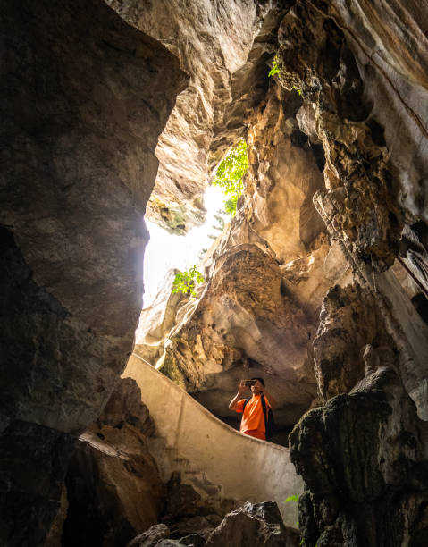 istock Asians man taking pictures with a smart phone at cave 1272259910
