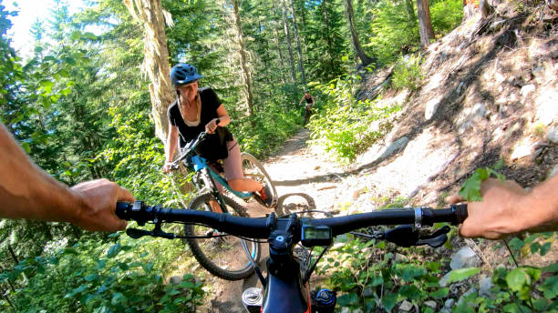 mountain bikers mulheres caminham ao longo do caminho florestal - 24454 - fotografias e filmes do acervo