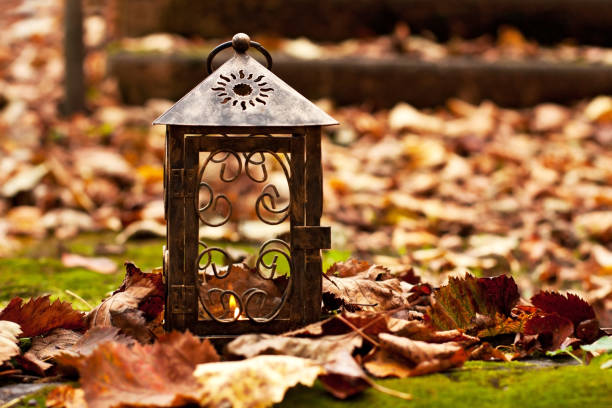 Colorful foliage  and vintage lantern in outdoors. Falling leaves natural background, selective focus with shallow depth of field