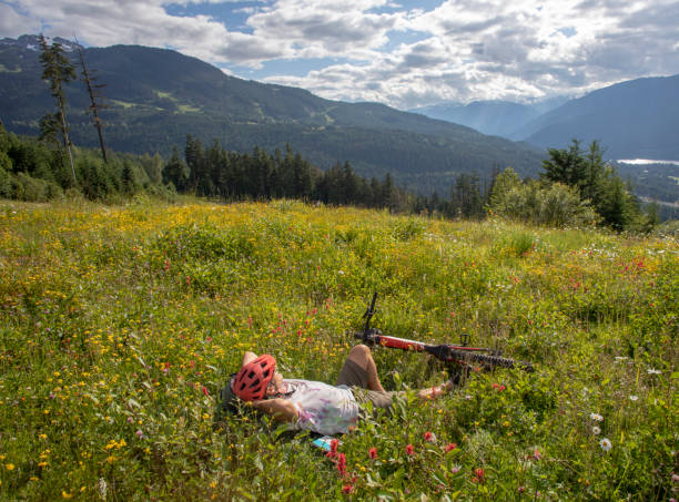 istock Mountain biker relaxes in grassy meadow 1272262864