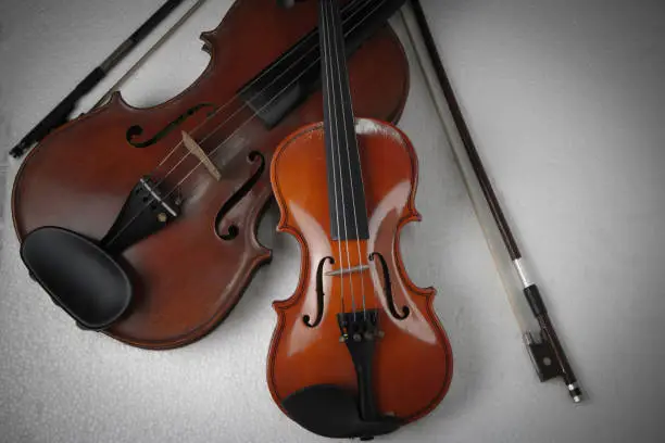 The smaller violin put beside bigger one,on background,show detail and different size of acoustic instrument