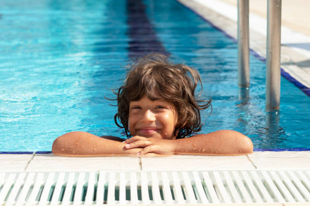 istock Happy Smiling Boy Looking At Camera In Swimming Pool 1272265341