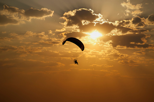 vuelo en paracaídas con motor cerca y puesta de sol photo