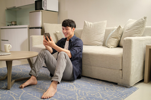 Asian Man using phone at home