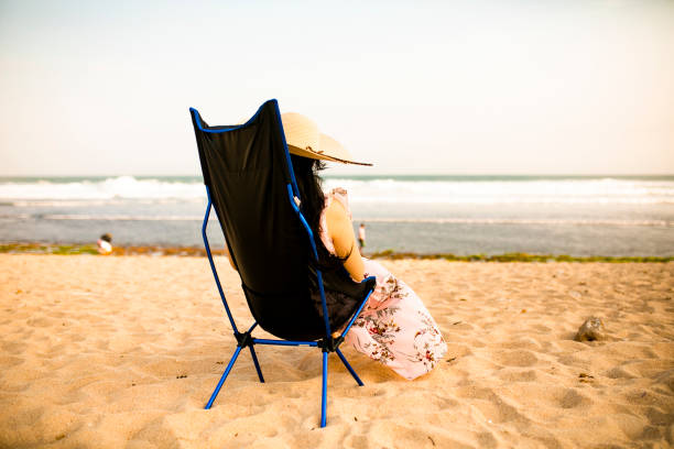istock asian pregnant sitting in deckchair on beach, reading book 1272267093