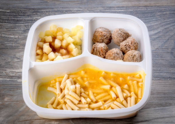 Pouring gravy sauce on french fries and curd cheese. Poutine in the making. Quebec and Canada regional food specialty