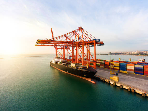 istock Logistics and transportation of Container Cargo ship with working crane bridge in harbor at sunset 1272270819