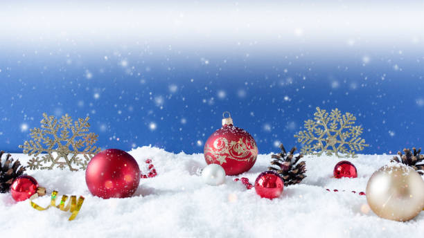 istock Christmas ornaments on snow over blue background with snowflakes. 1272272313