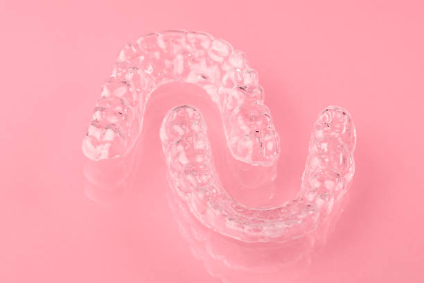 istock Invisible aligner or retainer for the upper and lower teeth on the pink background. Orthodontic therapy after straightening of teeth. 1272272336