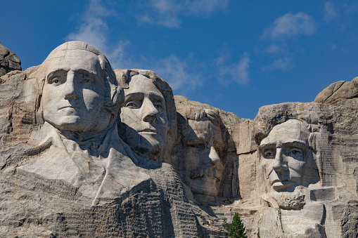 Landscape, daytime, close up image of all of Mount Rushmore against a clear blue sky.
