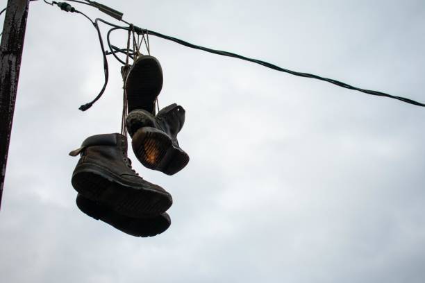 istock Boots Hanging From a Wire on an Overcast Sky 1272273489