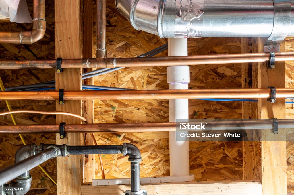 Ceiling with multiple utility lines - gas, electrical, water, internet, and sewer Typical construction industry installation of utilities in a house Water Pipe Stock Photo