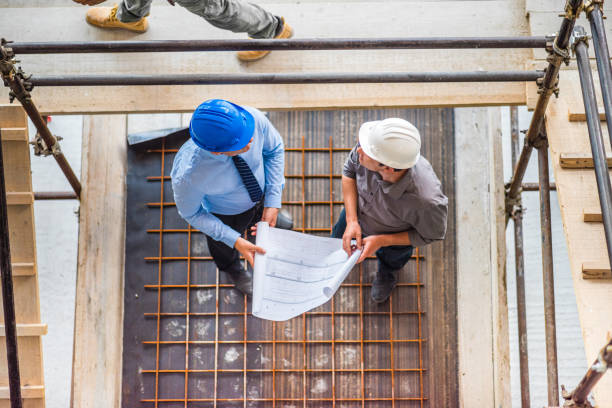 istock Investor and architect examining blueprints on a construction site 1272279414