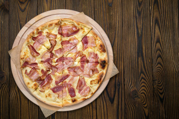 istock Pizza on a brown wooden table. 1272279524