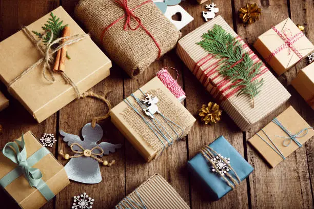 Photo of Christmas gifts on a wooden table. Ecological packaging. Zero waste holidays.