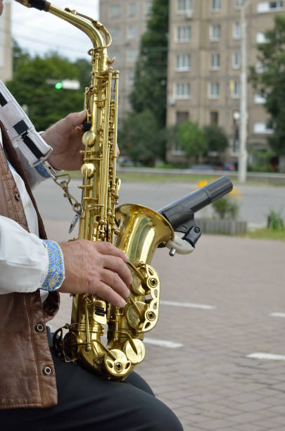 istock Old musician playing saxophone on empty street 1272280637