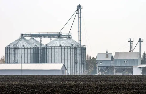 A plowed field in front of the grain-elevator complex for grain storage.