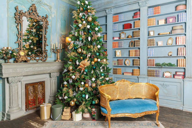 istock Classic Christmas New Year decorated interior room home library with fireplace. Christmas tree with gold ornament decorations. Modern classical style interior design apartment. Christmas eve at home 1272283514