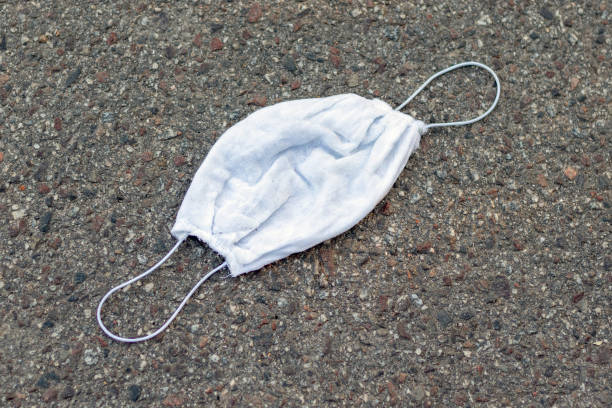 istock Used disposable medical mask lies on a sidewalk. 1272285982