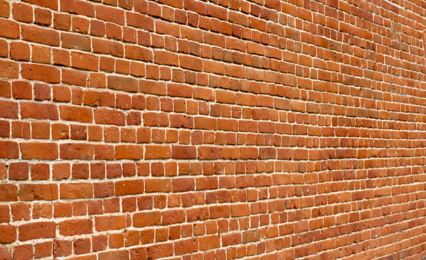 istock View along the old brick wall, blurred perspective, close-up. 1272287265