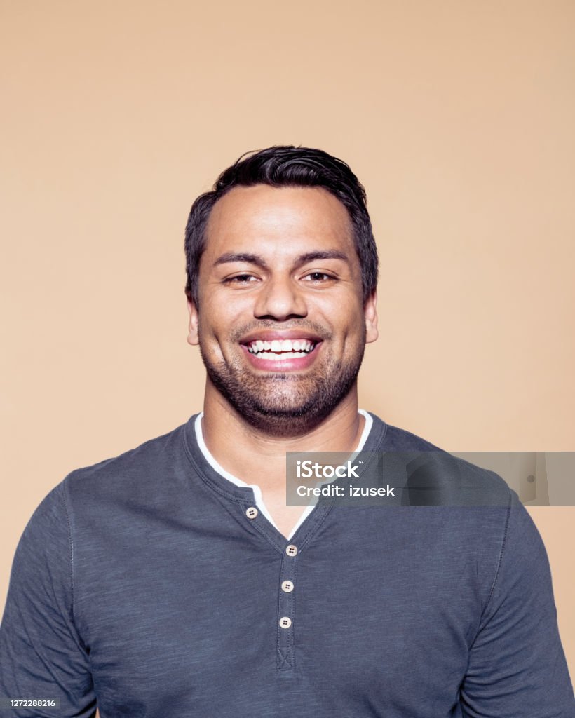 Cheerful entrepreneur against brown background Portrait of cheerful entrepreneur. Happy businessman against colored background. He is wearing t-shirt. Happiness Stock Photo