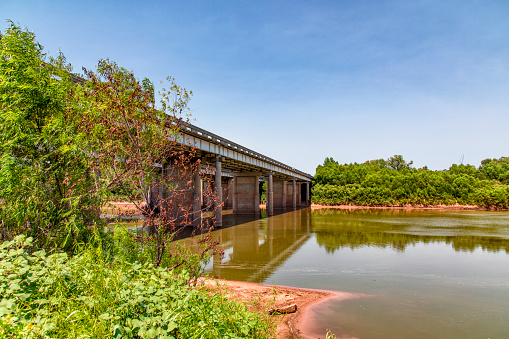The interstate 35 bridge crossing from Texas into Oklahoma over the Red River on a summer afternoon