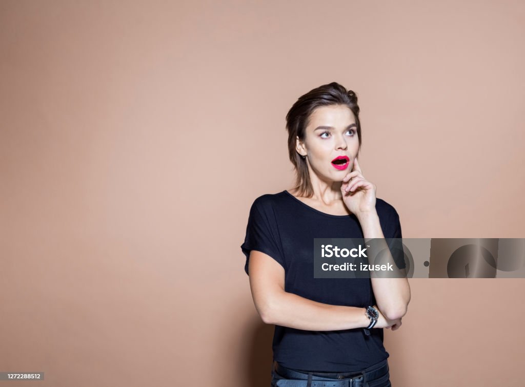 Shocked businesswoman against pink background Shocked entrepreneur with arms crossed looking away. Businesswoman standing against pink background. She is in casuals. Surprise Stock Photo