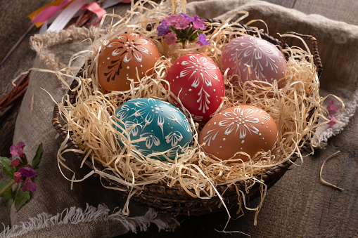 Colorful Easter eggs decorated with wax in a basket on a table
