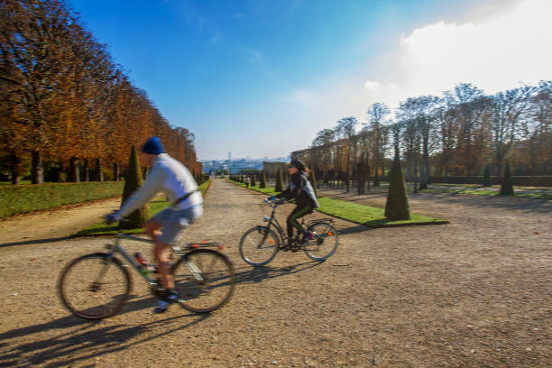 istock Blurred  from motion pair on bicycles  (man and woman ) at  park  Saint-Cloud in Paris  . 1272292031