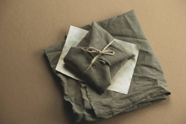 istock gift box wrapped in green cloth on a brown  background 1272292067