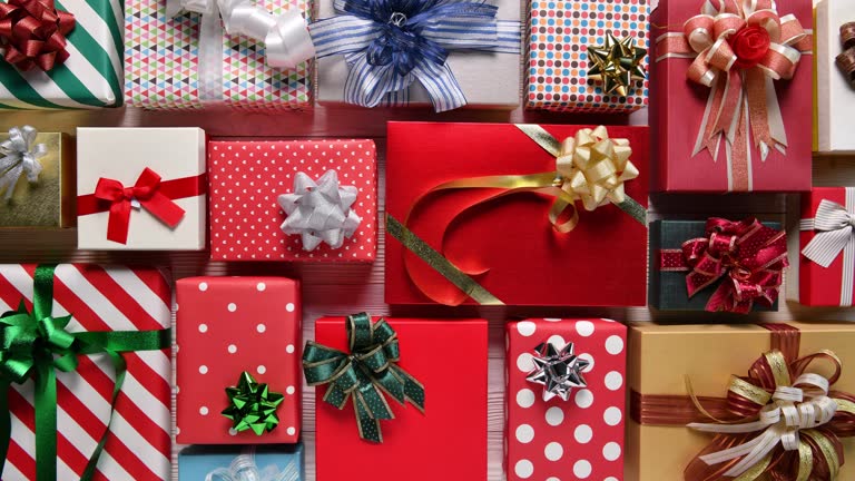 Top view christmas holiday gift boxes on wooden table, stop motion