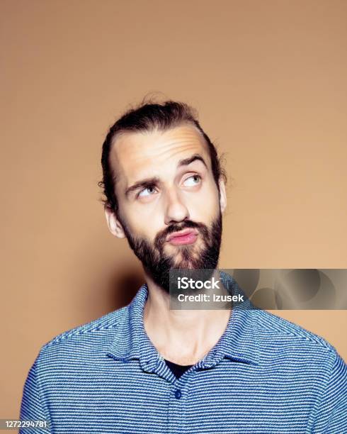 Contemplating Businessman Over Brown Background Stock Photo - Download Image Now - 25-29 Years, Adult, Adults Only