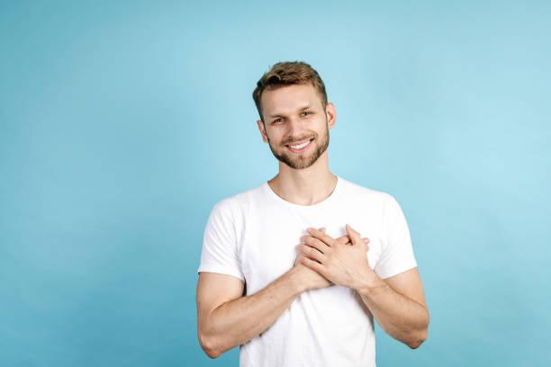 istock Young adult guy holding hands on chest 1272296244