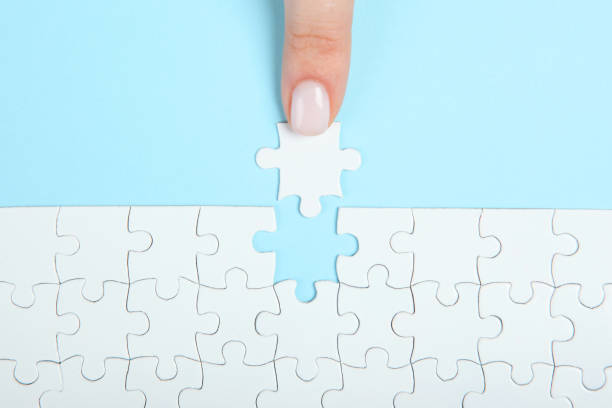 istock Collect puzzle. Hand and puzzle pieces on the table 1272297709