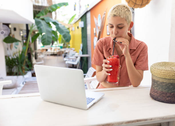 istock Young women using laptop and drinking frozen cocktail 1272298072