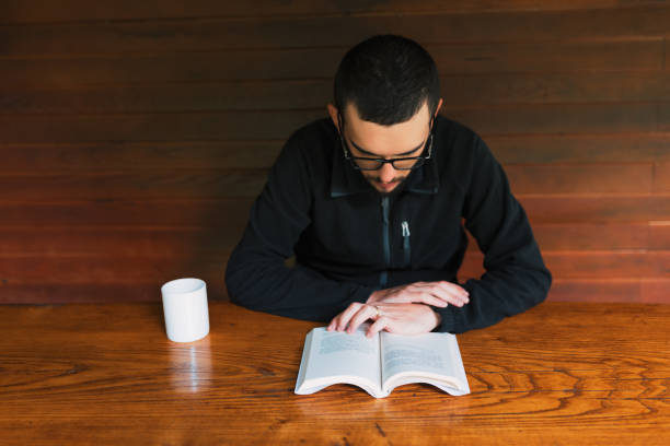 istock Young men reading book and drinking  cup of coffee 1272299896