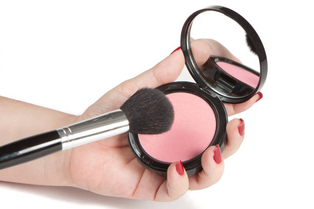 istock Detail of woman's hand with red nails using makeup brush 1272302053