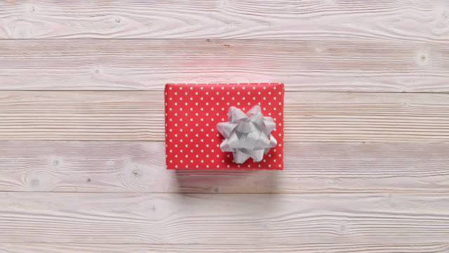 Top view christmas holiday gift boxes on wooden table, stop motion