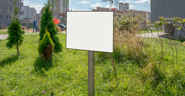 istock empty signboard with blank white space for mockup message on wooden pole on lawn of backyard 1272304510