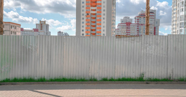 istock large metal empty fence on sidewalk construction site with new buildings background 1272304513