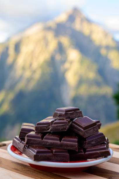istock Handmade pure dark swiss chocolate and Alpine mountains on background 1272305270