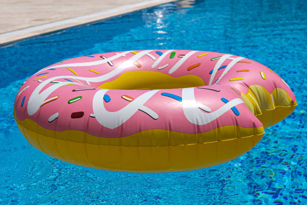 istock pink inflatable donut doughnut floating mattress in swimming pool. Beach pool accessories. Summer holiday concept 1272306302