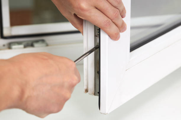 istock handyman adjusting white pvc plastic window indoors. worker using screwdriver to repair upvc window. homework maintenance 1272306425