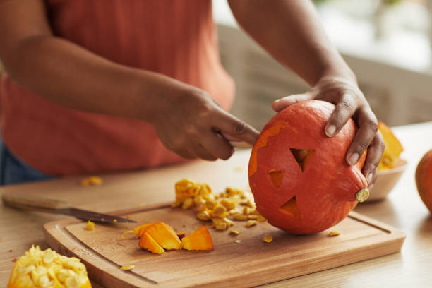 istock Woman Carving Pumpkin For Halloween 1272311510
