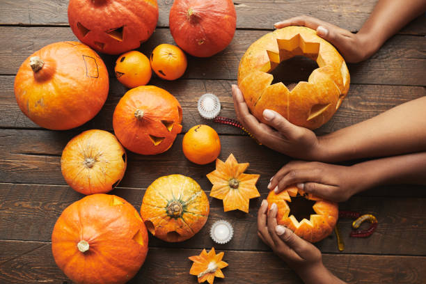 Pumpkin Flat Lay From above view shot of hands holding pumpkin for Hallowing party on dark brown wooden table carving stock pictures, royalty-free photos & images