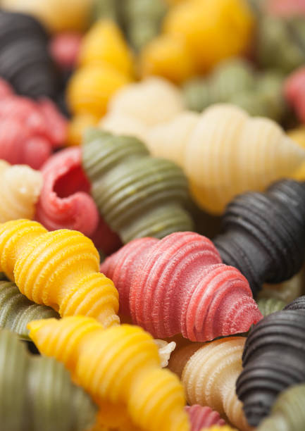 istock Fresh raw conchiglioni tricolore pasta as texture background. 1272313510