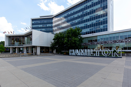 Hamilton, Ontario, Canada - August 23, 2020: Hamilton city hall in Ontario, Canada with Hamilton sign in front of the building.