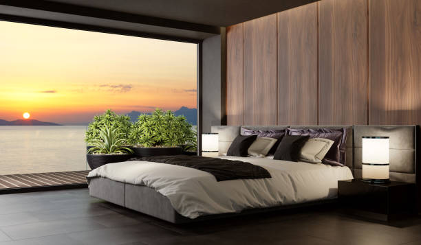 Sunset Luxurious apartment master bedroom interior with large terrace Modern matte wooden bedroom interior with large terrace. Master bedroom interior.
Modern king size bed with black gloss side tables. 
Black carpet and ceiling with down lighters. Light stone marble flooring. 3d rendering. owner's bedroom stock pictures, royalty-free photos & images
