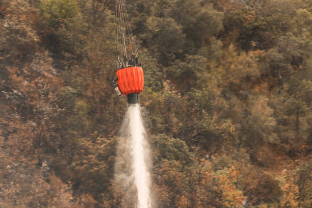 El bierzo, leon, spain - august 15th 2025:Helicopter equipped with a water bucket flying to extinguish wildfires in el bierzo, leon, spain
